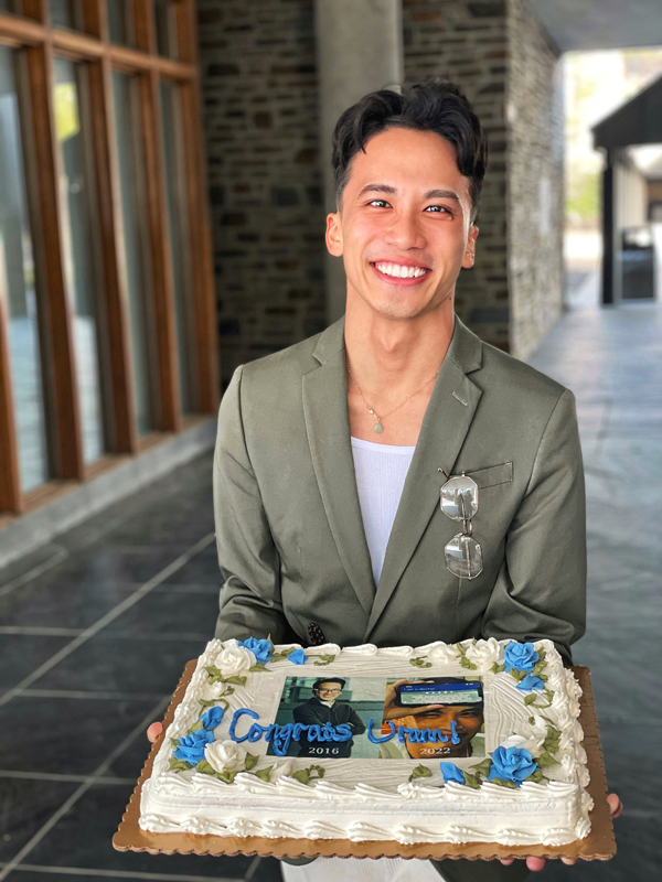 Urann Chan, holding a celebration cake after his thesis defense